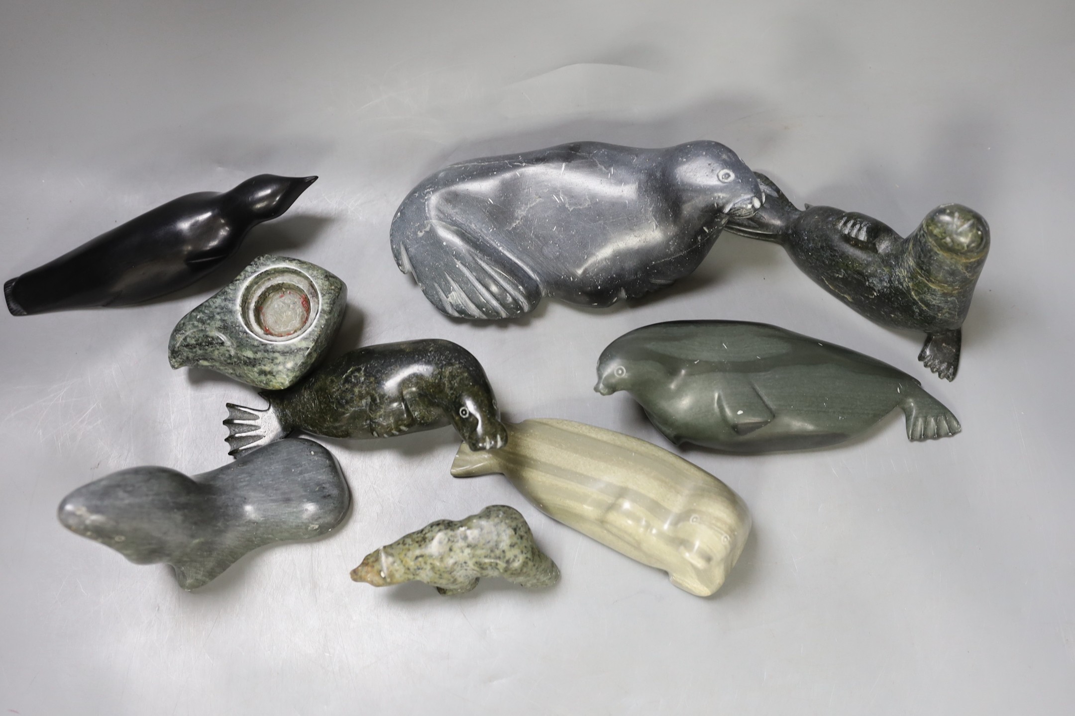 A collection of carved Canadian Inuit seal figures, largest 18 cm long (9)